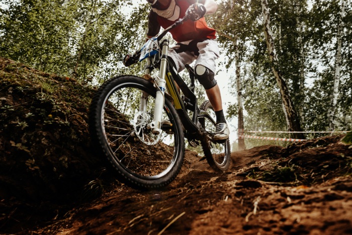 Mountain biker riding downhill in the forest with optical safety glasses