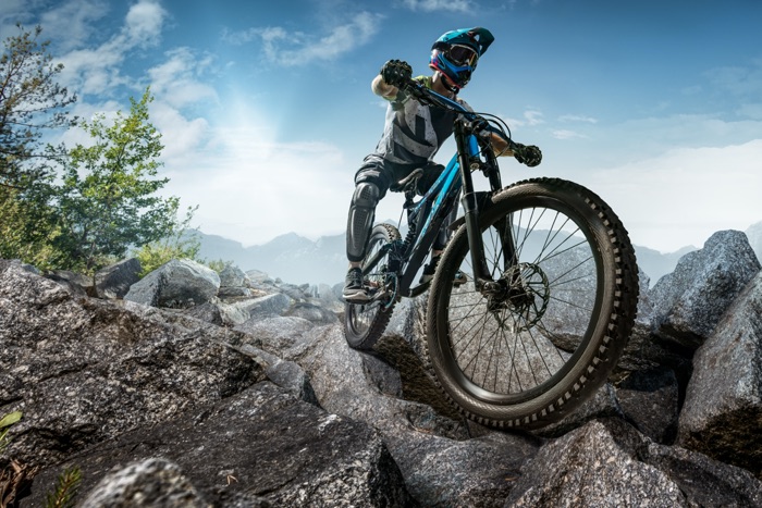 MTB rider with mountain bike on stony terrain