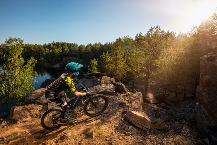 MTB downhiller with optical mountain bike goggles before steep descent