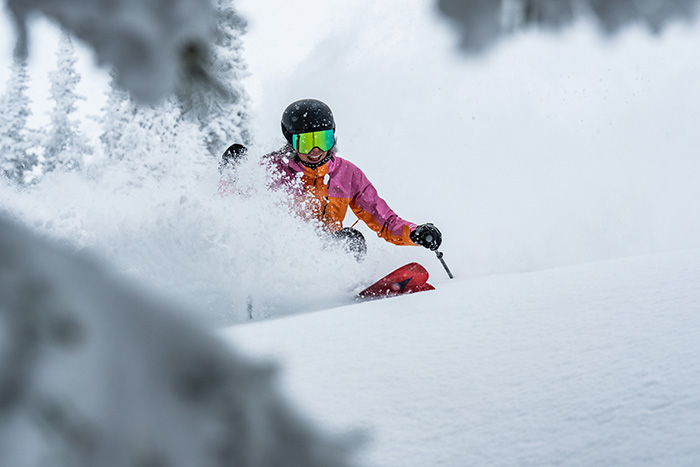 Skifahrerin mit optischer Skibrille bei einer rasanten Hangabfahrt auf der Skipiste